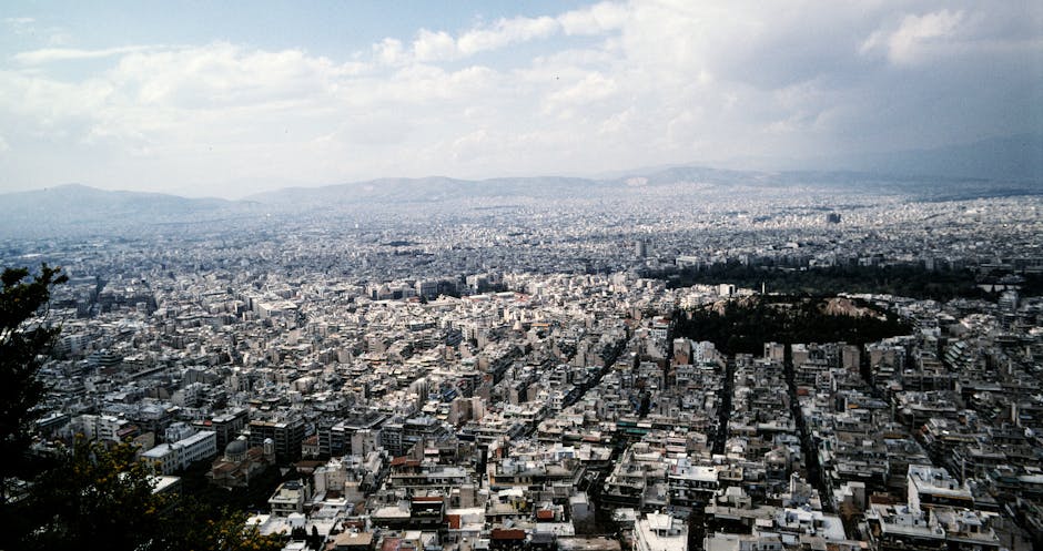 Breathtaking aerial view of Athens, Greece, showcasing urban sprawl under a cloudy sky.