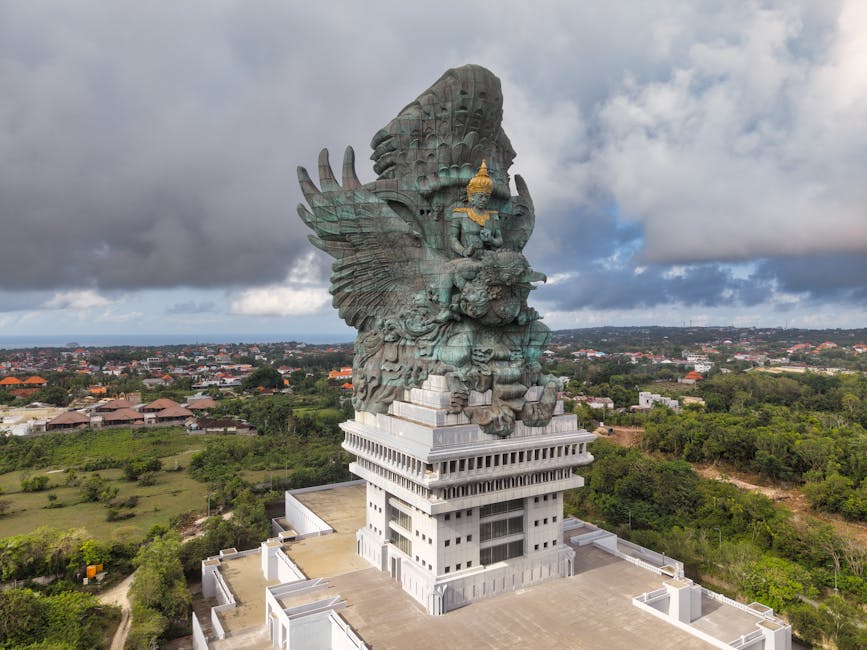 Stunning aerial shot of the Garuda Wisnu Kencana statue in Bali, under dramatic skies.