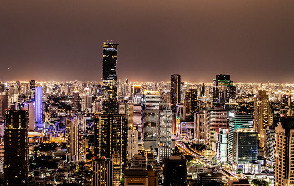 A vibrant night view of Bangkok's illuminated skyline featuring modern skyscrapers.
