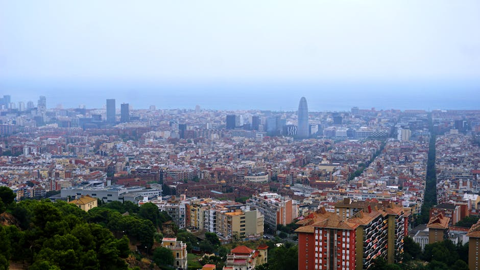 A breathtaking aerial view of Barcelona's cityscape featuring the skyline and Mediterranean Sea in the background.