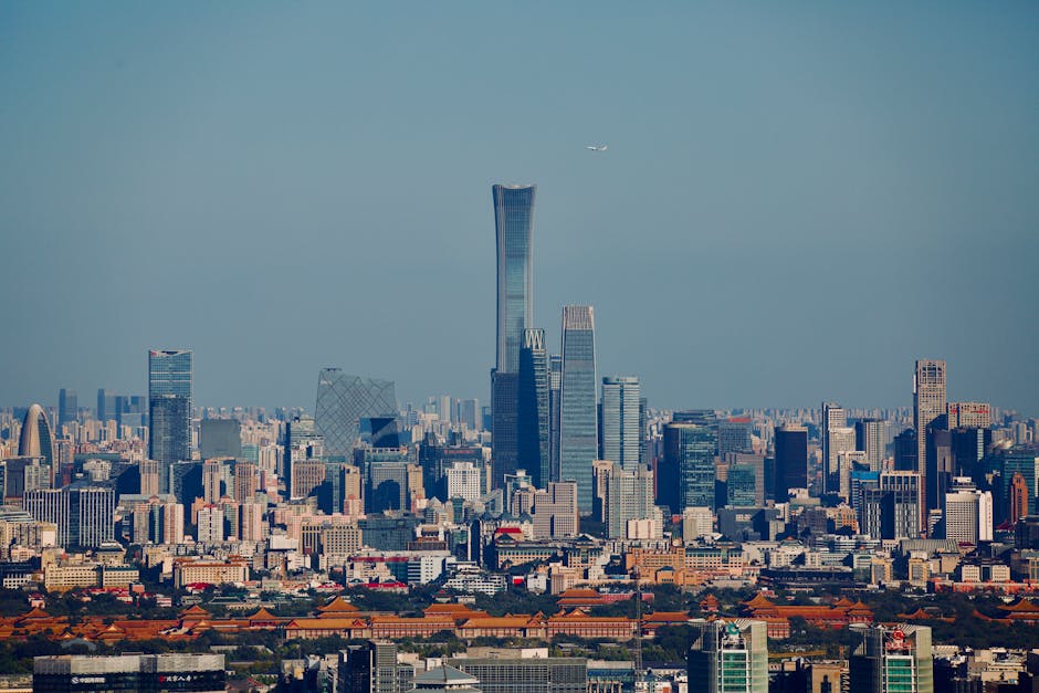 Aerial view of Beijing's skyline featuring modern skyscrapers against a clear blue sky.