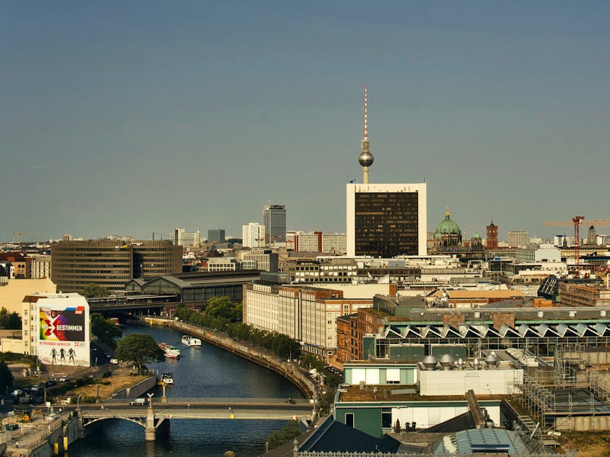 Aerial view of Berlin cityscape with the iconic TV Tower and Spree River under a clear sky.