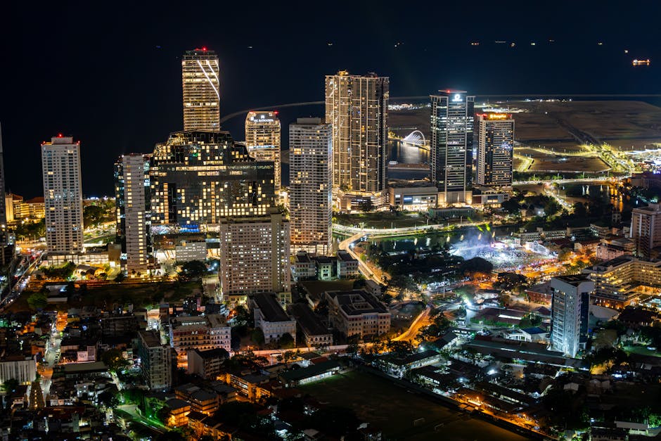 A vibrant aerial view of Colombo's illuminated skyline at night, showcasing modern architecture.