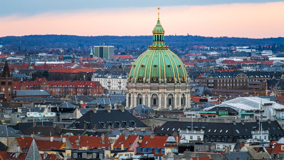 Aerial view of Frederik's Church in Copenhagen with its iconic green dome against a winter sunset.
