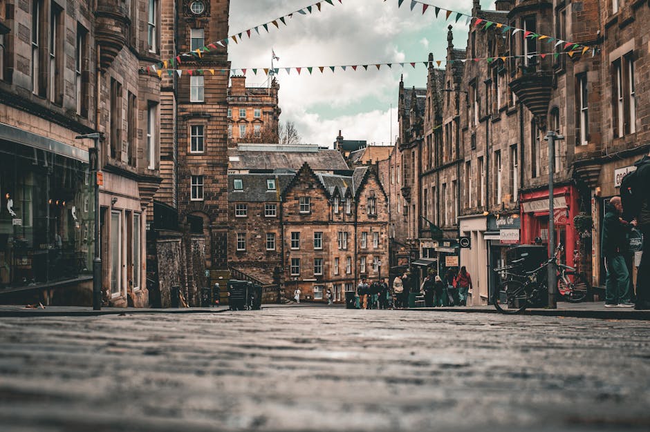Scenic view of a historic street in Edinburgh, Scotland, featuring traditional architecture and colorful bunting.