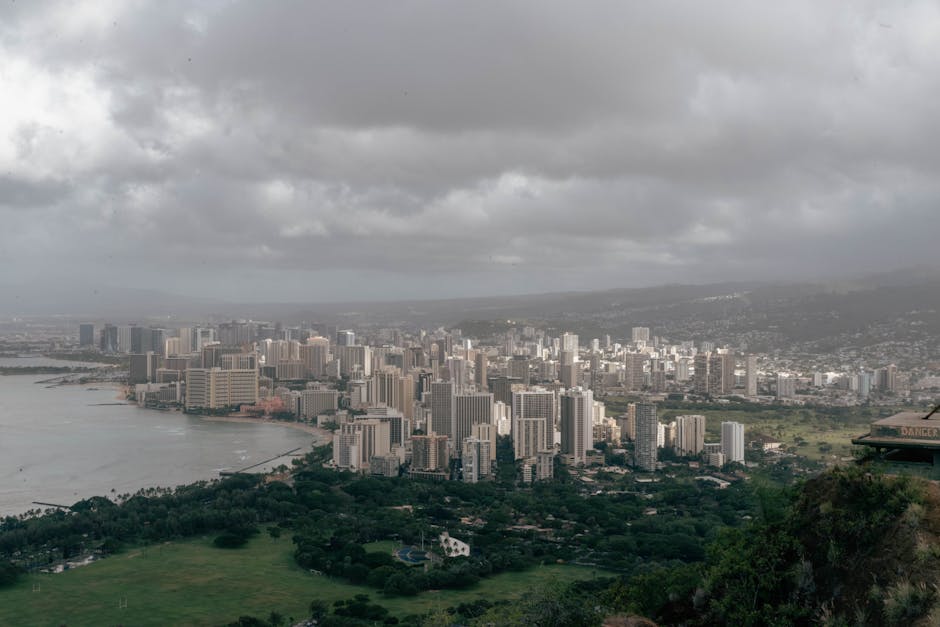 Aerial view of Honolulu's skyline with overcast skies, capturing urban skyscrapers and coastal scenery.