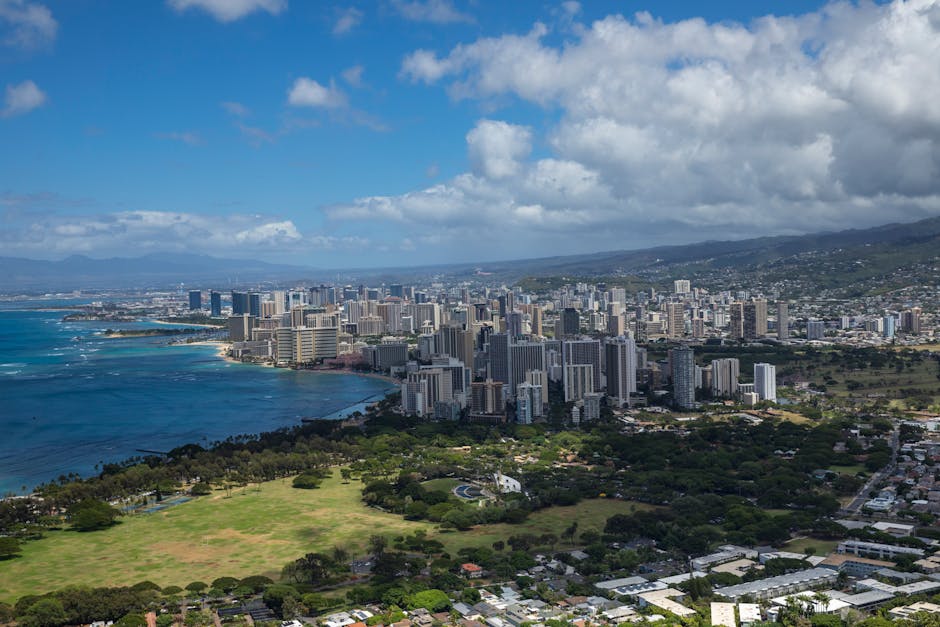 High-altitude view of Honolulu skyline with ocean and greenery.