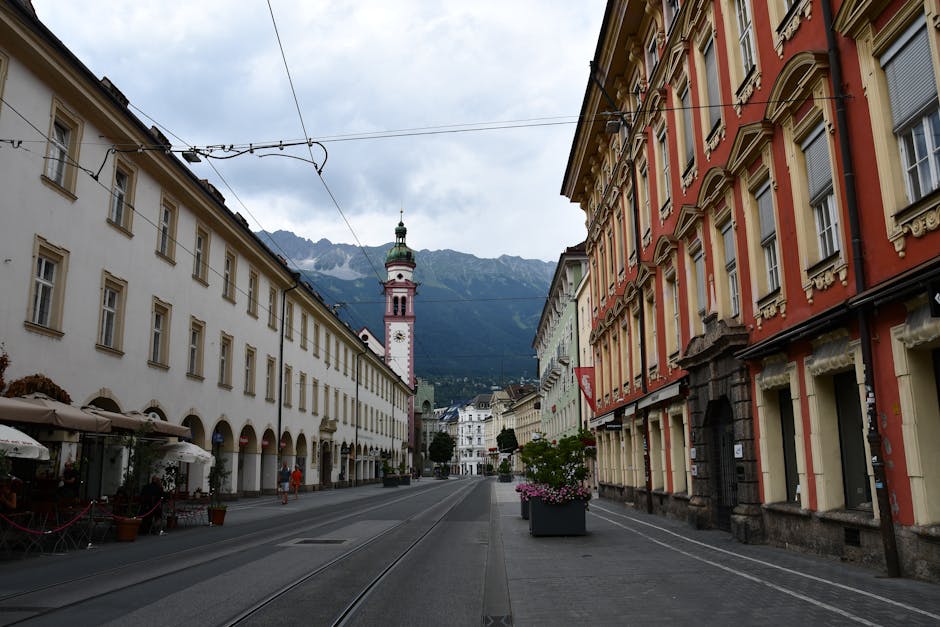 Explore Innsbruck's picturesque Maria-Theresien-Strasse with stunning architectural details and mountain backdrop.