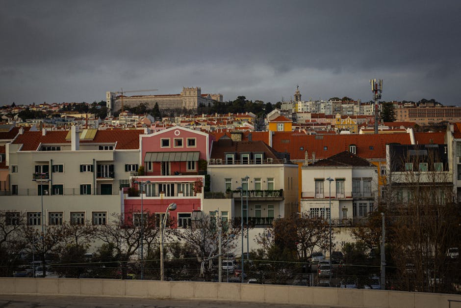 Scenic view of Lisbon's colorful rooftops under an overcast sky, showcasing the city's architectural charm.