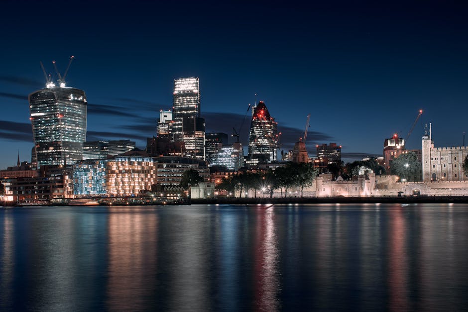 Captivating night view of modern London skyline with reflections on the Thames.