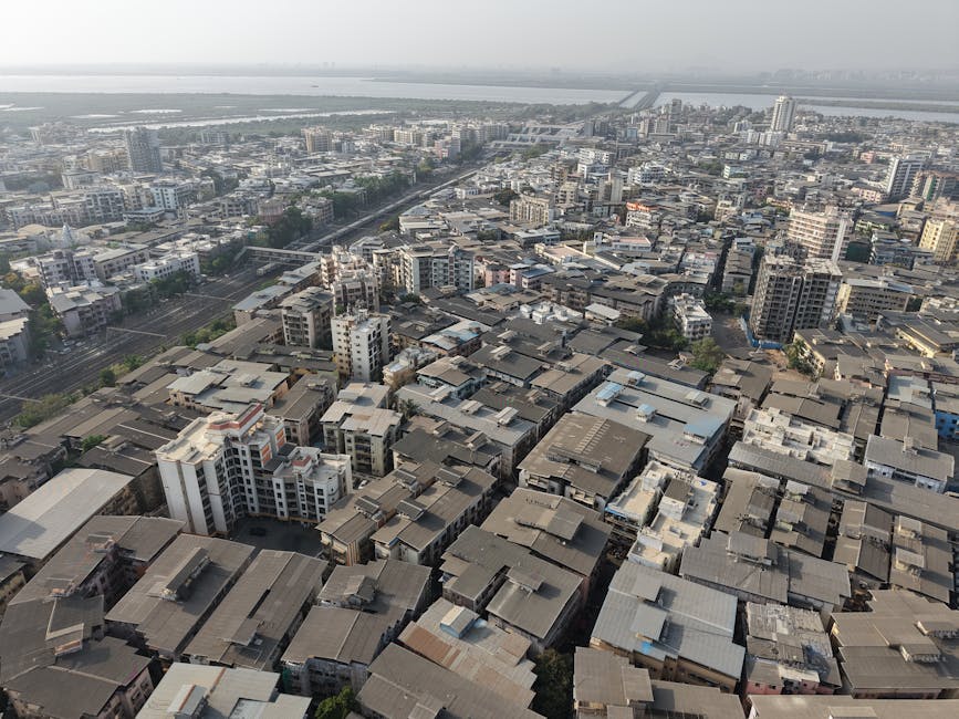 Panoramic aerial view of Mumbai's sprawling urban landscape showcasing dense buildings and roads.