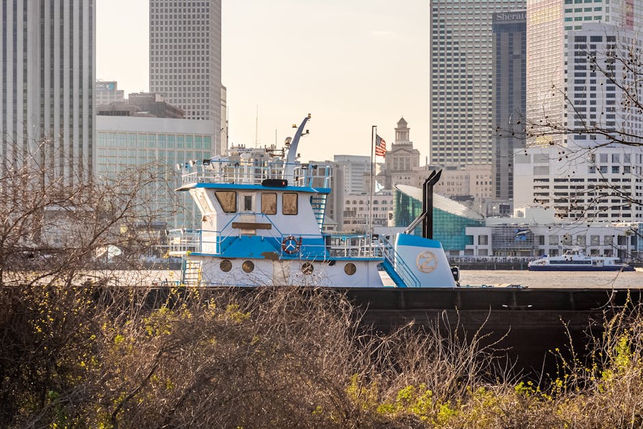 A tugboat on the Mississippi River with the iconic New Orleans skyline in the background.