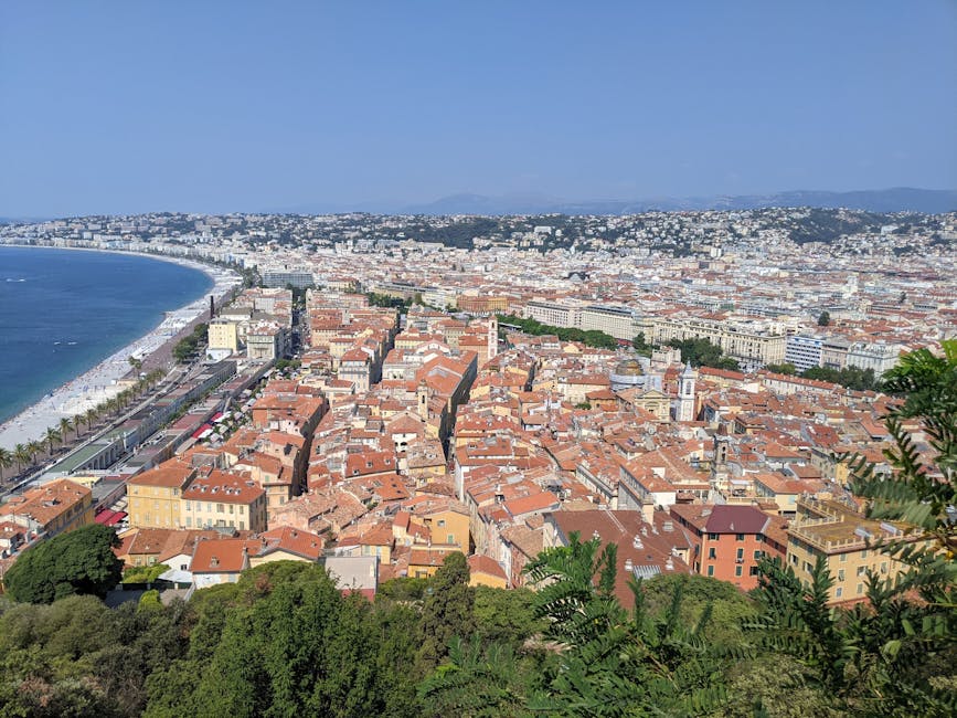 A stunning aerial view of Nice, France, showcasing the coastline and vibrant cityscape under clear blue skies.