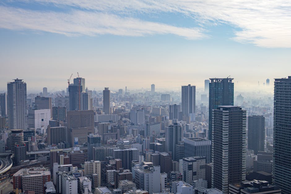 Stunning aerial view of Osaka's modern skyscrapers under a bright blue sky.