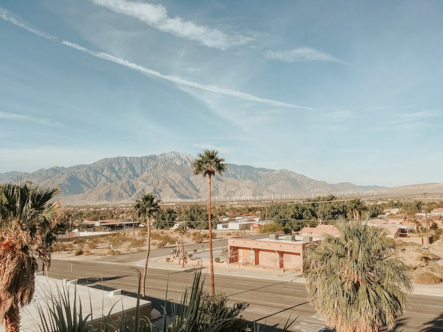 Stunning desert landscape in Palm Springs, CA, featuring mountains, palm trees, and clear skies.