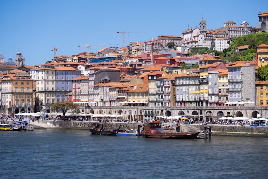 Colorful waterfront view of Ribeira District, Porto's historic charm under a bright sky.