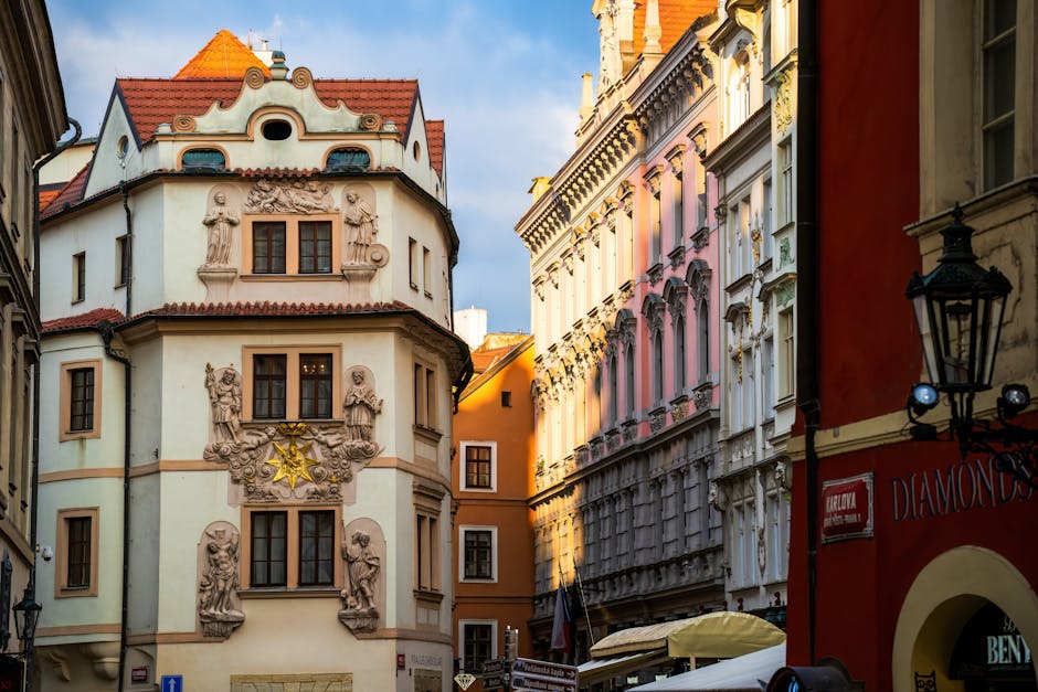 Charming street view of historic architecture in Prague city center, showcasing ornate facades in golden sunlight.