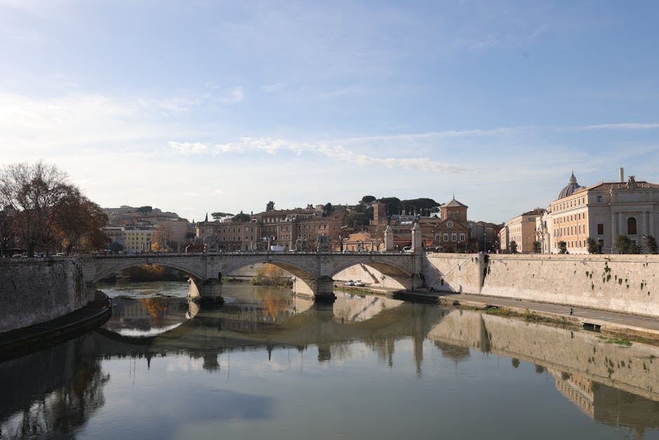 Discover the iconic Ponte Sant'Angelo over the Tiber River in Rome, Italy, with historic architecture.