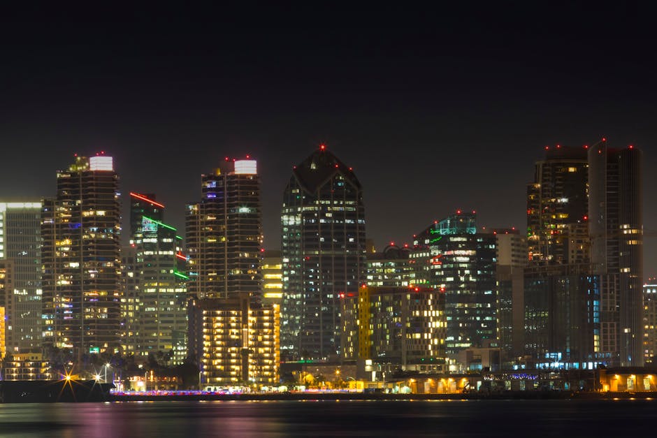 Stunning view of San Diego's illuminated skyline at night with city lights reflecting on the water.