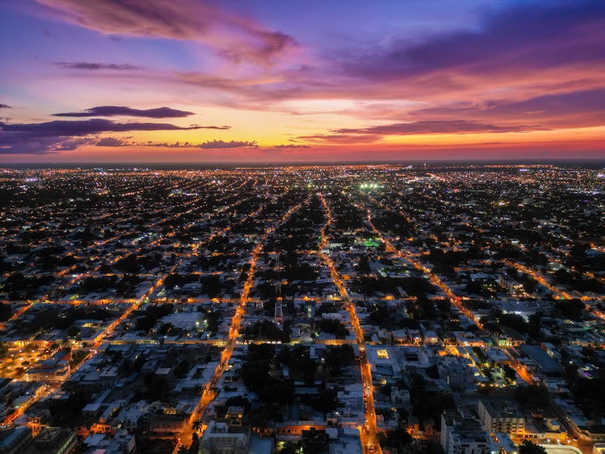 Stunning aerial view of Mérida, Mexico cityscape during a vibrant sunset with glowing street lights.