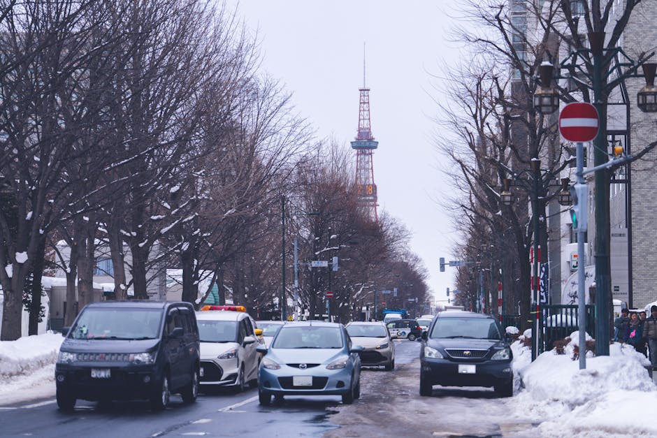 Winter scene in Sapporo, Japan. Snowy street with cars and Sapporo TV Tower.