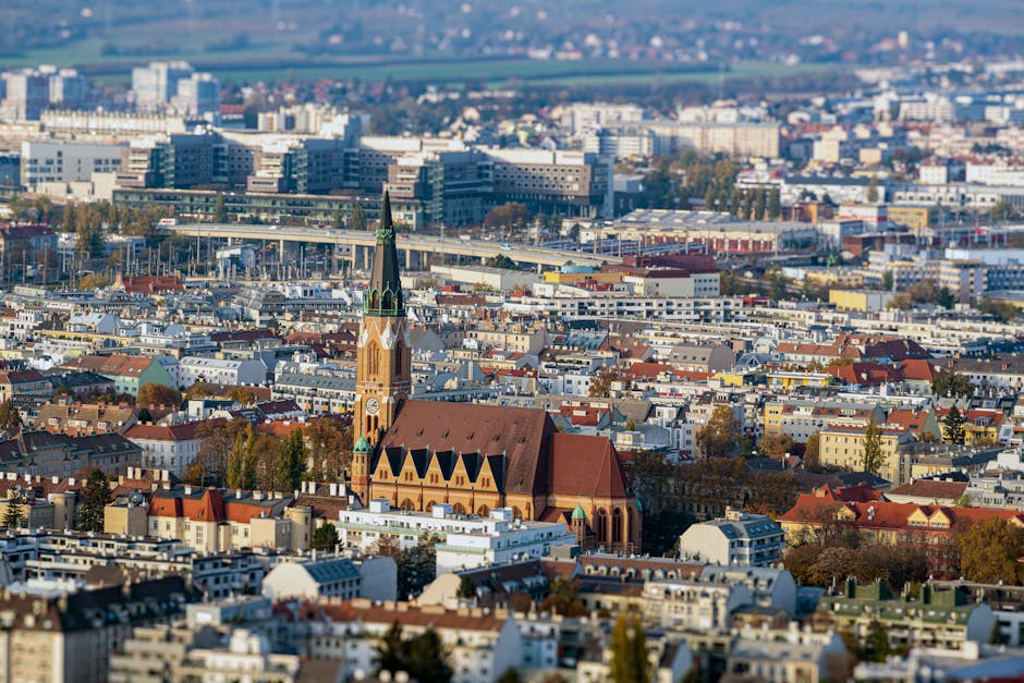 Stunning aerial view of Vienna showcasing historic church spire amidst cityscape.