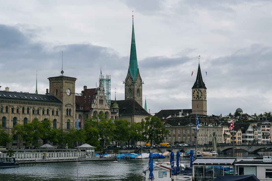 Scenic view of Zürich with church towers and river on a cloudy day.